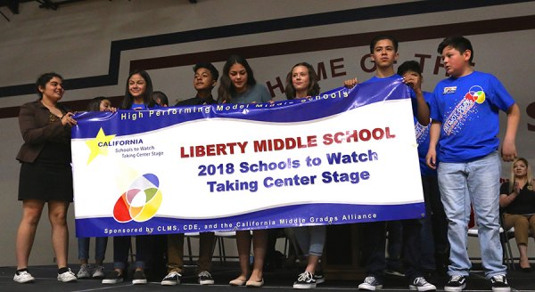 Proud Liberty Middle School students unfurl 2018 Schools to Watch Banner during Friday's (March 16) recognition event.